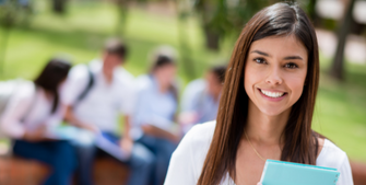 Image of a student holding books and smiling