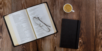 Book, glasses, and cup of coffee on a desk