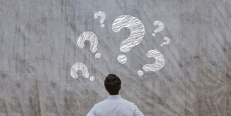 Image of a student looking at a chalkboard with question marks